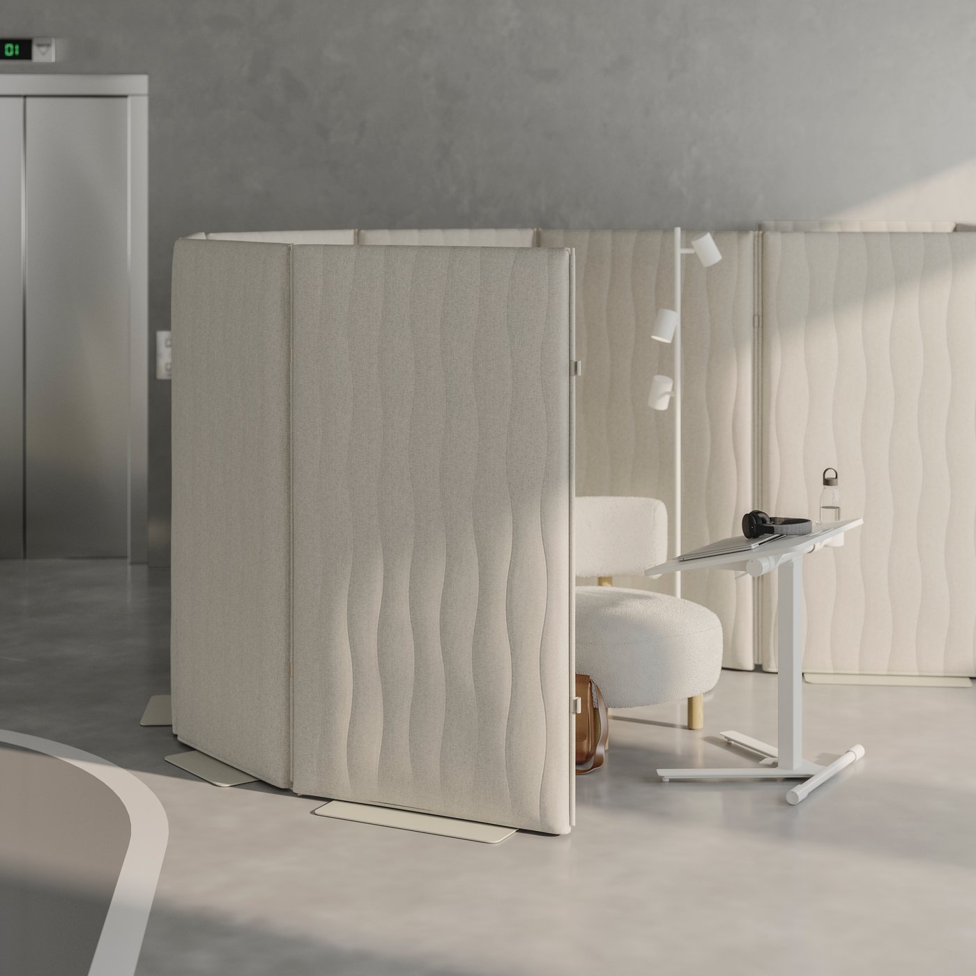 Quiet focus area of an open plan office, with standing acoustic screens, comfortable seating and a tilted laptop table.