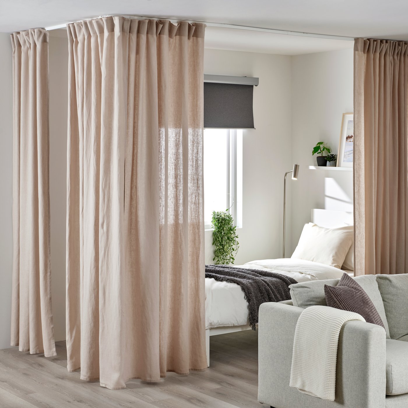 VIDGA gardinskinner med hjørnesæt omkring en fritstående seng.