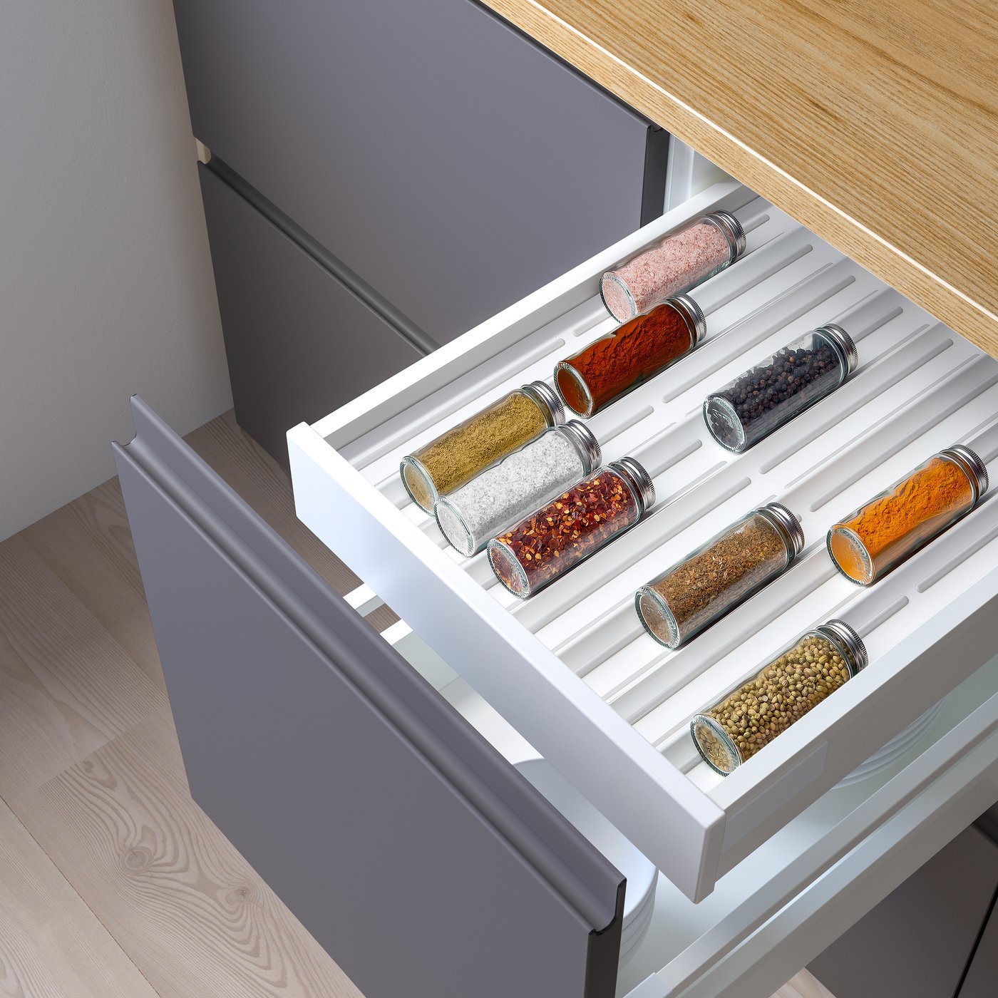 Un cassetto della cucina aperto con all'interno un comodo portaspezie e barattoli di spezie
