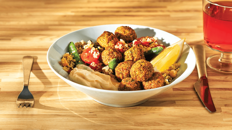 Falafelbällchen mit Couscous und Aioli Sauce in einem Teller angerichtet