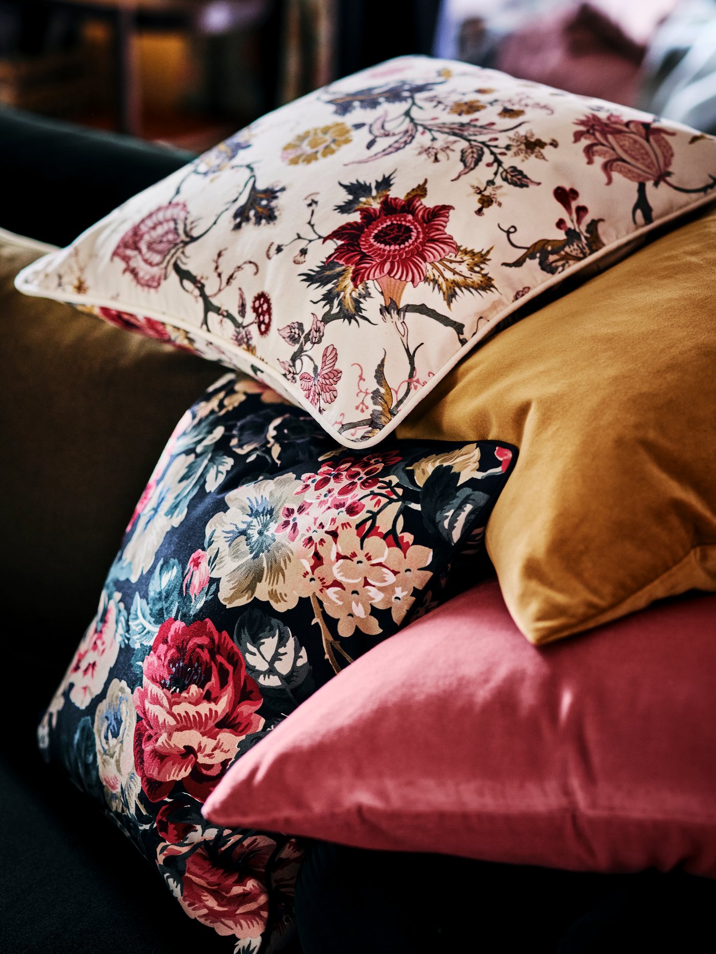A pile of cushions made up of a LEIKNY cushion cover, a NÄSSELKLOCKA cushion cover, and two SANELA cushion covers.