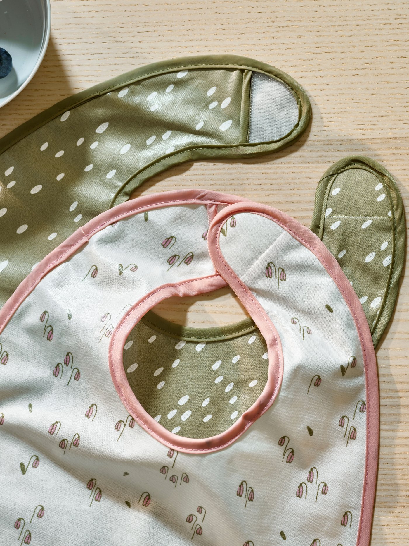 Ein grün-weißes GULDVÄVARE Lätzchen