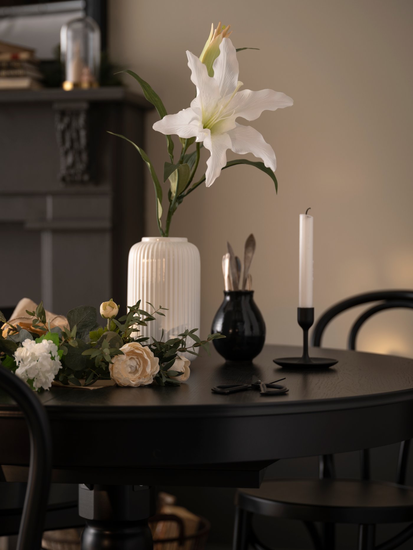 Een witte STILREN vaas op een zwarte tafel