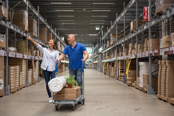 Two people shopping large items at IKEA self serve