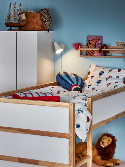 Children's room with loft bed with solid pine frame, soft toys, a wardrobe, soft cushions that imitate air balloons or the London bus.