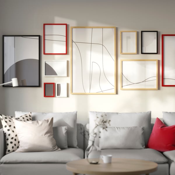 A living room with red, black, and wooden RÖDALM picture frames above a sofa.