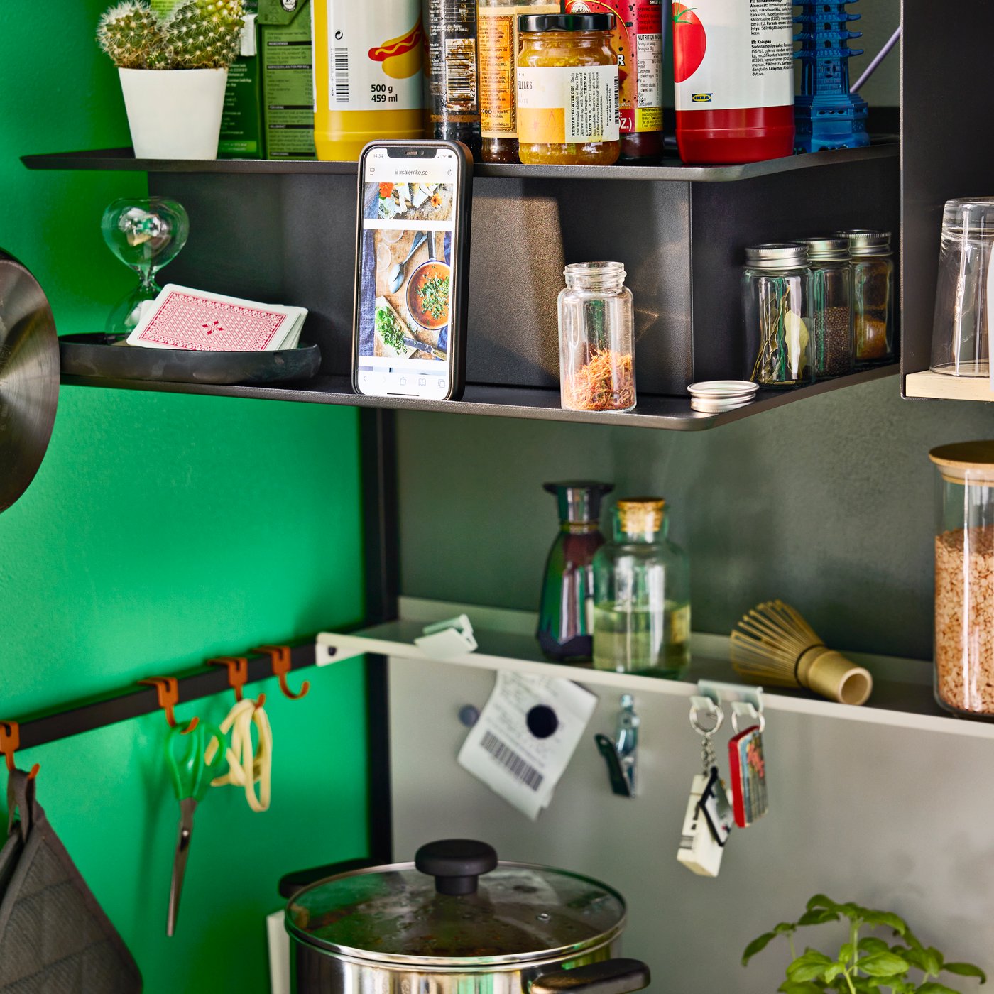 Sleek black wall mounted VIGGBO extractor hood with built in shelf for food storage and phone.