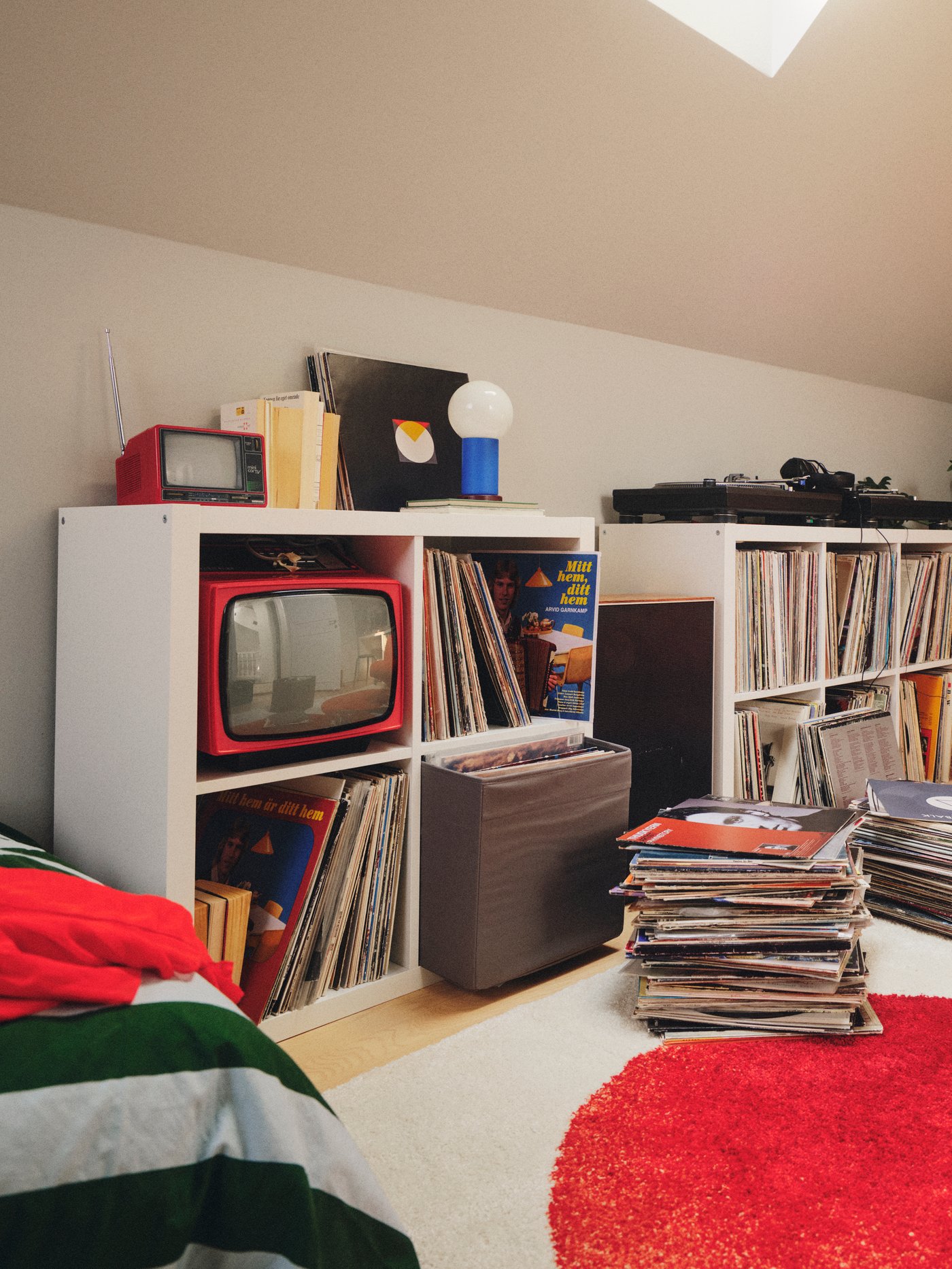 Una habitació amb diverses prestatgeries KALLAX blanques amb quatre compartiments plens de discos. Hi ha més registres apilats a la vora.