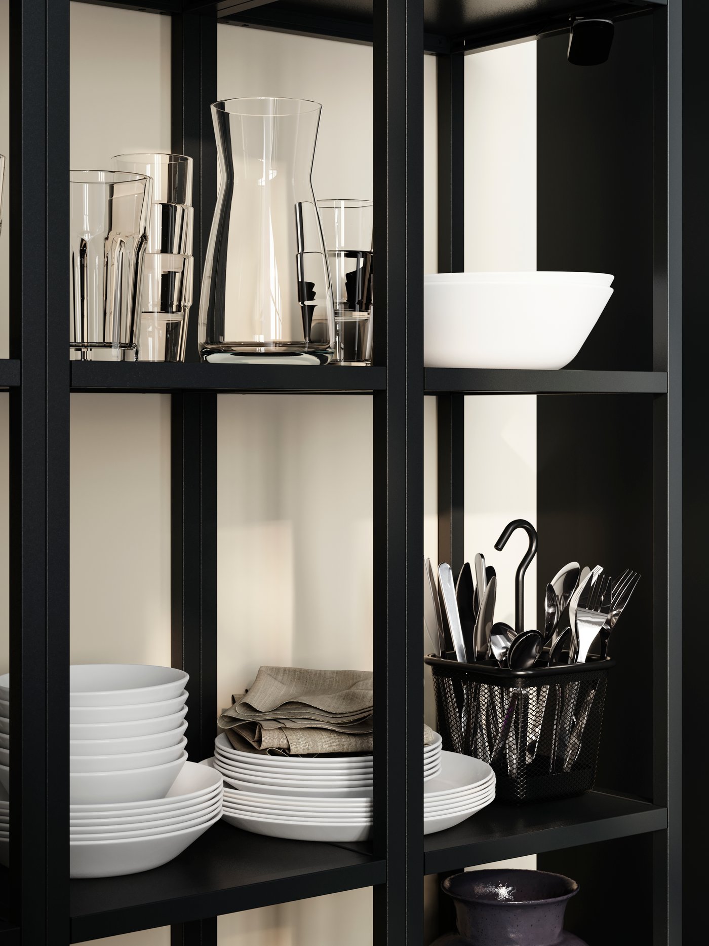 OFTAST bowls stacked on a black shelf alongside glasses and cutlery in a basket, with napkins neatly folded.