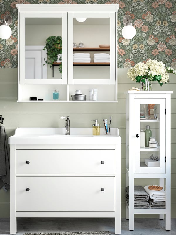 Un bagno con colori neutri, un lavabo HEMNES con due cassetti e un grande mobile a specchio.