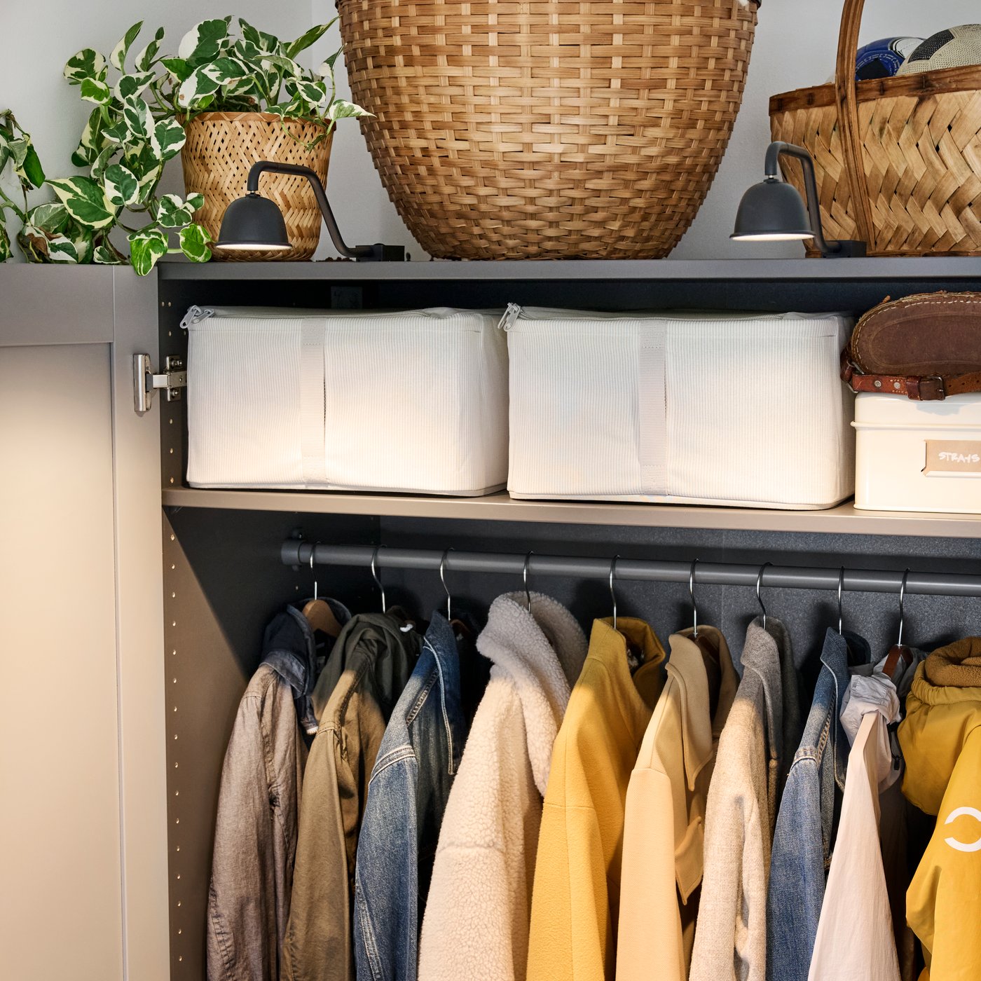 Close-up of PAX GULLABERG wardrobe with doors open to show the neat order with lighting, shelves and clothes hanging below.