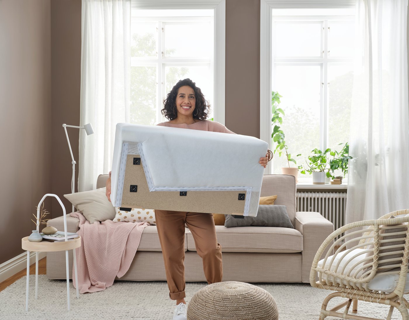 Kvinna som bär ett armstöd till en soffa, 