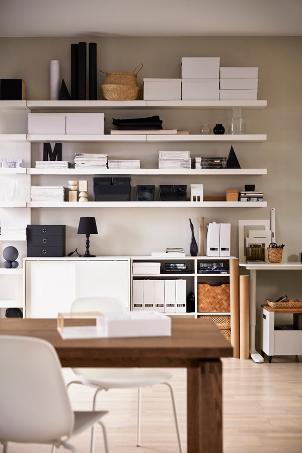 Clear black KUGGIS box with lid on a white shelving system for the living room.