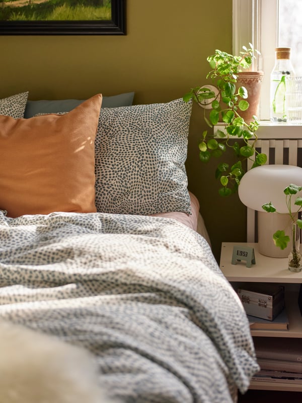 A VILDKORN stomach-sleeper pillow and a VILDKORN side-back-sleeper pillow on a bed made with TRÄDKRASSULA bed linen.