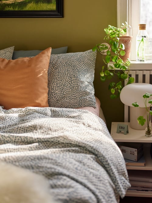 Un oreiller VILDKORN pour position ventrale et un oreiller VILDKORN pour positions dorsale et latérale sont posés sur un lit garni de linge de lit TRÄDKRASSULA.