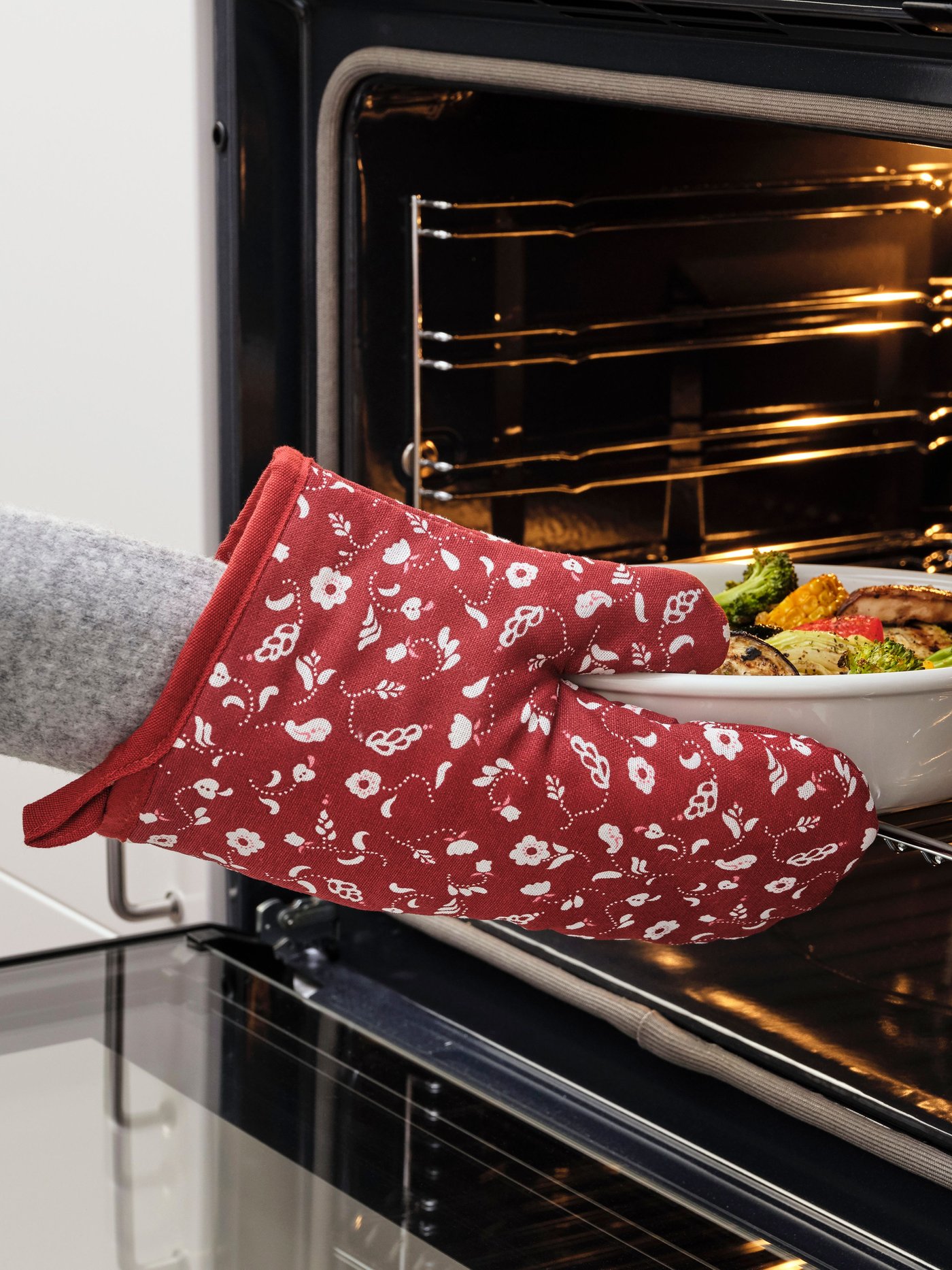 A patterned/red INAMARIA oven glove