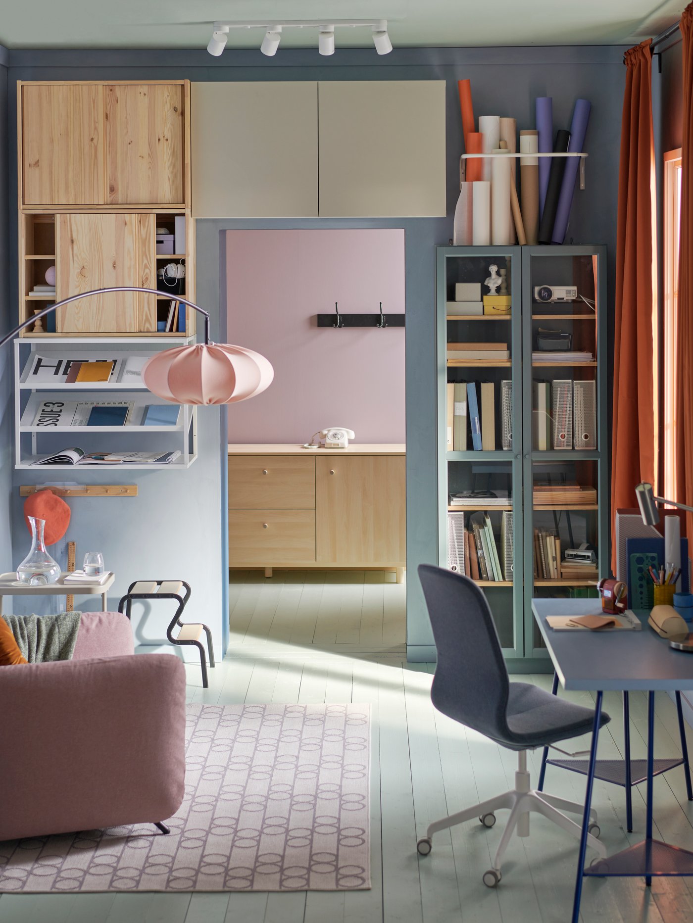 Habitación con un escritorio con armarios IVAR con puertas correderas encima y alrededor del marco de una puerta.