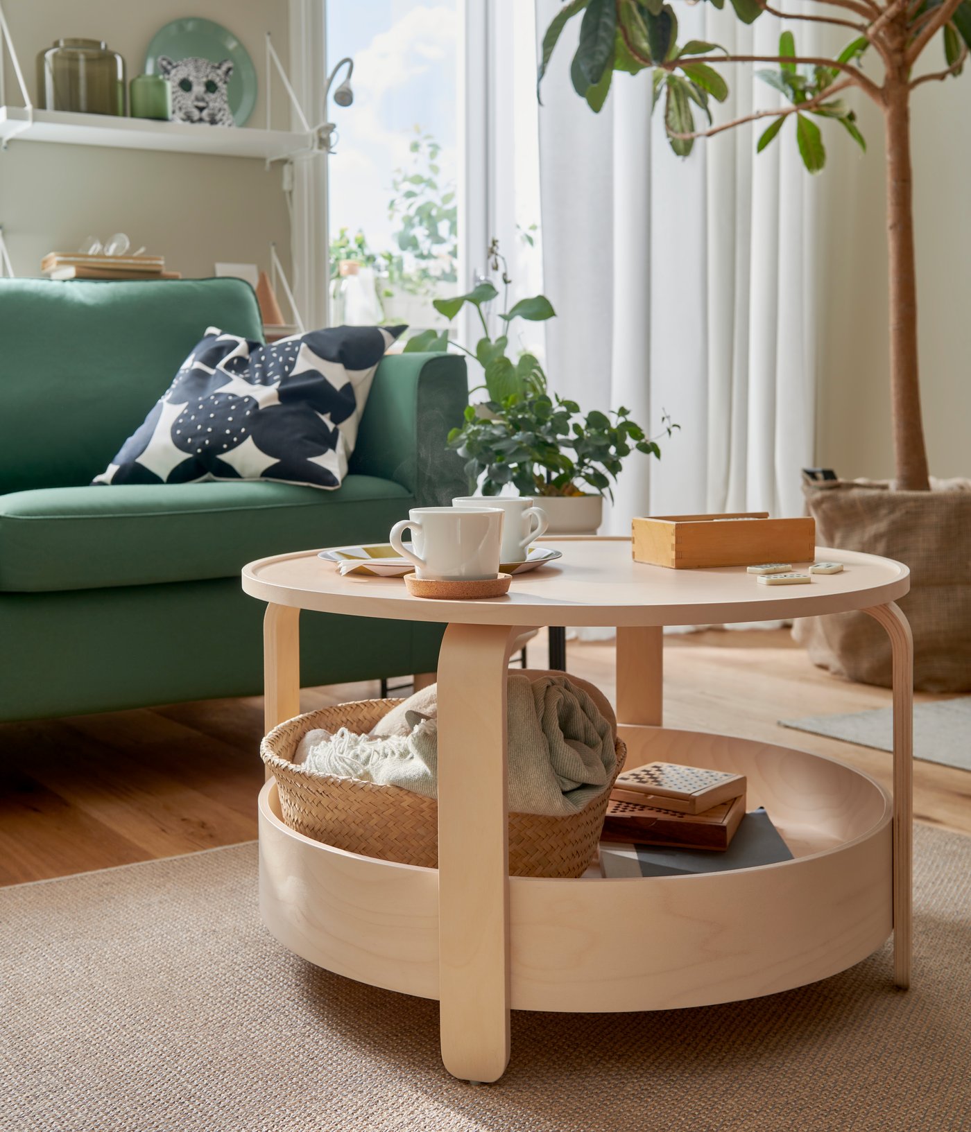 A light wooden BORGEBY coffee table in the living room in front of a green sofa.