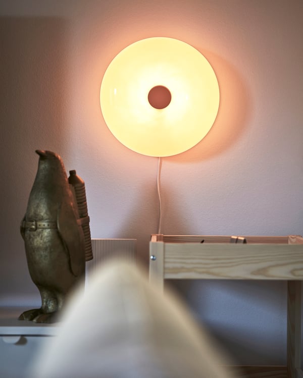 En orange VARMBLIXT lampa på väggen.