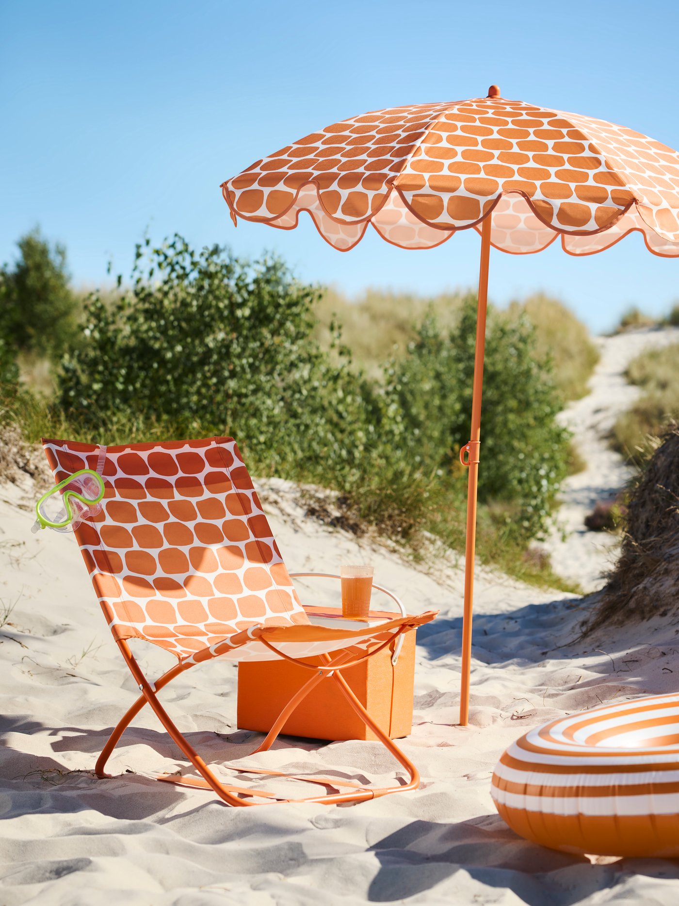 Krzesło składane i paraol z serii STRANDÖN na plaży.