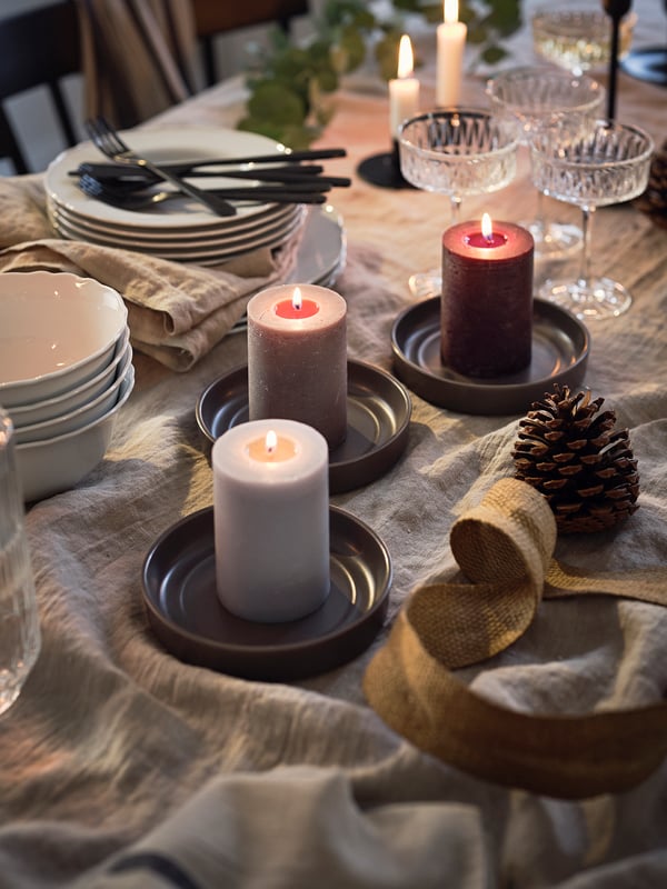 Klassisk dækket julebord med tændte bloklys.