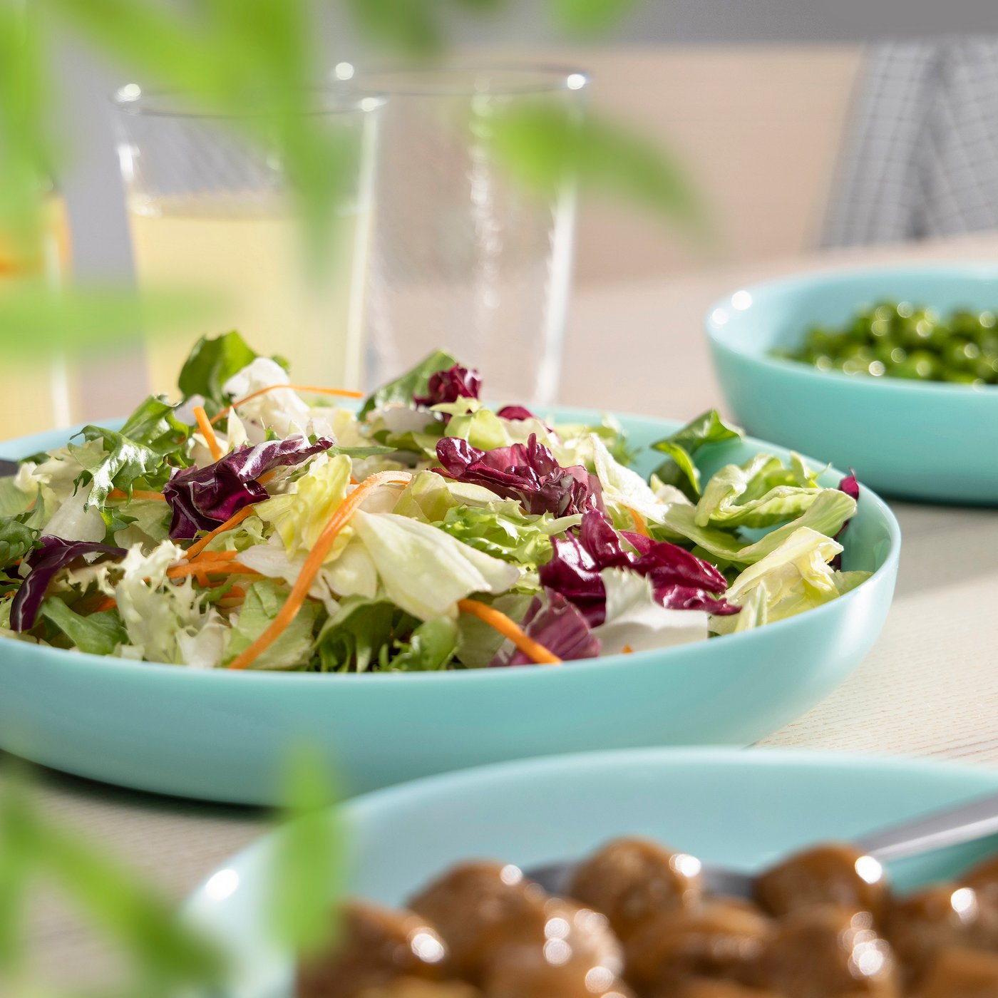 VITBLECKA turquoise plates with food inside them.