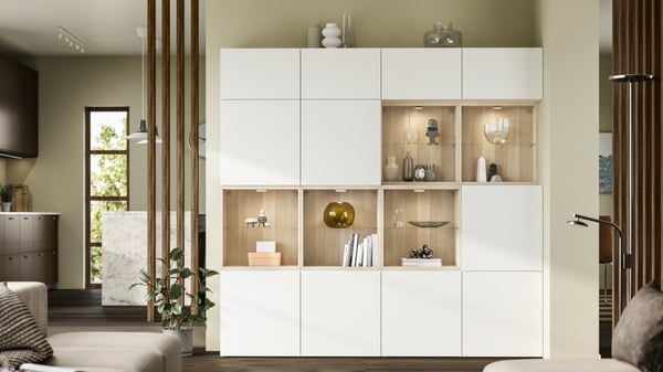 白い扉とオーク調オープン棚が並ぶ大型収納。リビングをすっきり見せつつ、ライト付きディスプレイで雑貨や本を美しく飾れる壁面収納。