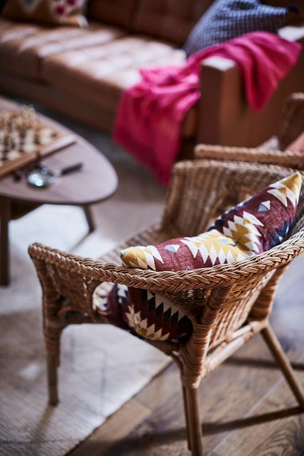 Fotel PERSBOL i czarny stolik kawowy KRAGSTA ustawione przed szarobrązową witryną LANESUND.