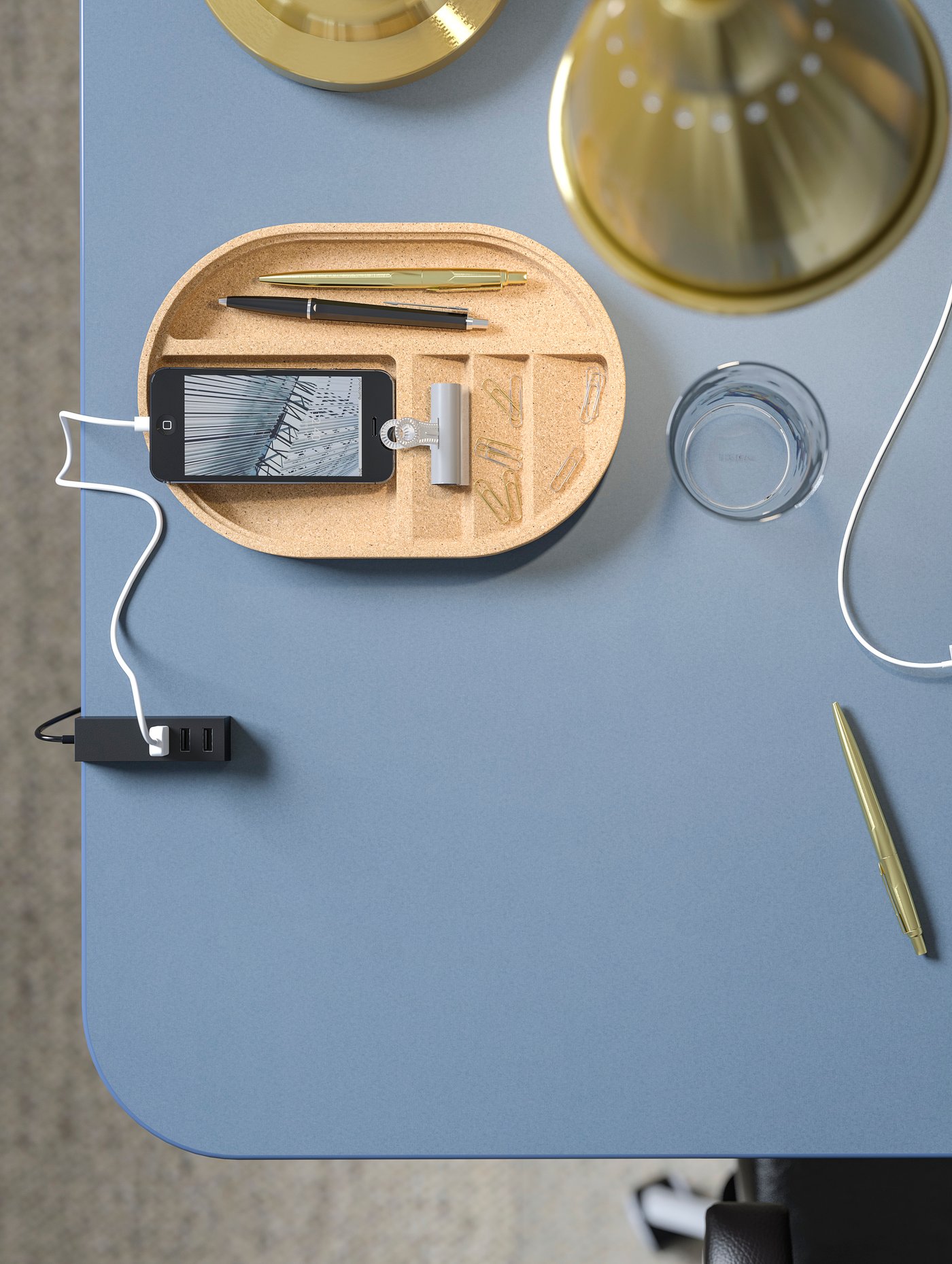 سطح طاولة مشمع أزرق ناعم BEKANT عليه كوب وهاتف ومستلزمات مكتبية مختلفة مثل الأقلام والأقلام الرصاص.
