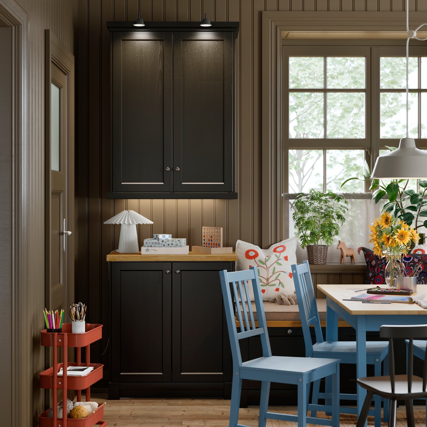 A kitchen featuring a SEKTION base cabinet with two black-grey LERHYTTAN doors, placed next to a trolley and dining chairs.