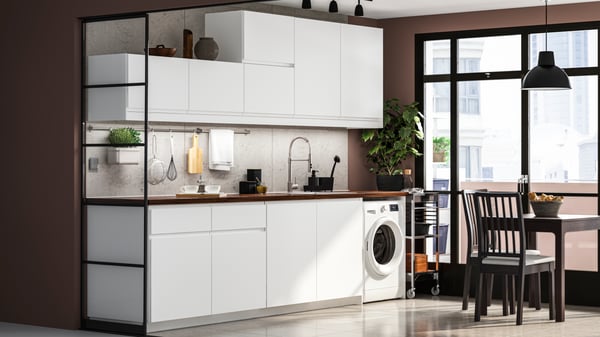 A modern matt white IKEA VOXTORP kitchen with a dark worktop and EKEDALEN brown table and chairs.