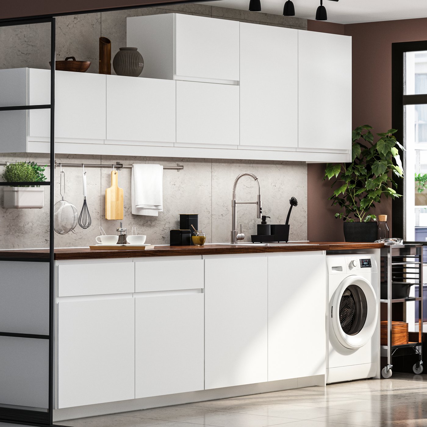 A modern matt white IKEA VOXTORP kitchen with a dark worktop and EKEDALEN brown table and chairs
