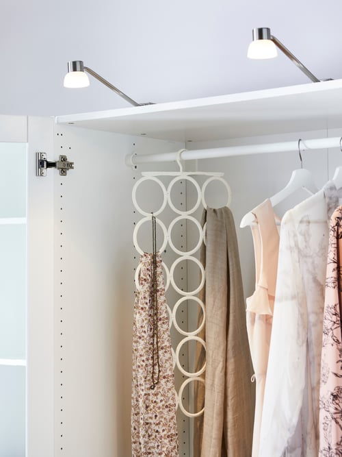 Bedroom with white wardrobe, clothes rail, white multi-use hanger, white wooden hangers, LED cabinet light, clothes, scarves.