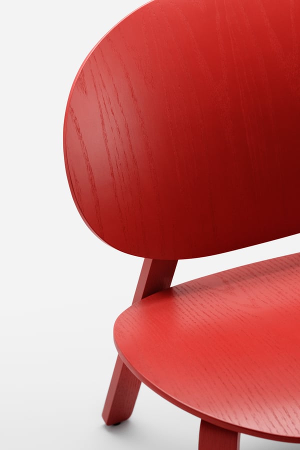 Ein IKEA Stuhl in Rot steht auf einem weissen Boden.