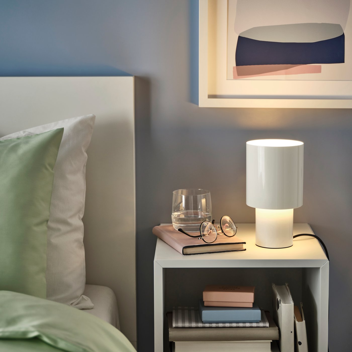 A dimmable/white SPETSBOJ table lamp in the bedroom