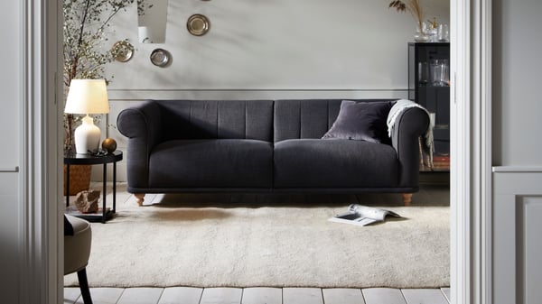 Grey VISKAFORS sofa in a bright room with a beige STOENSE rug.