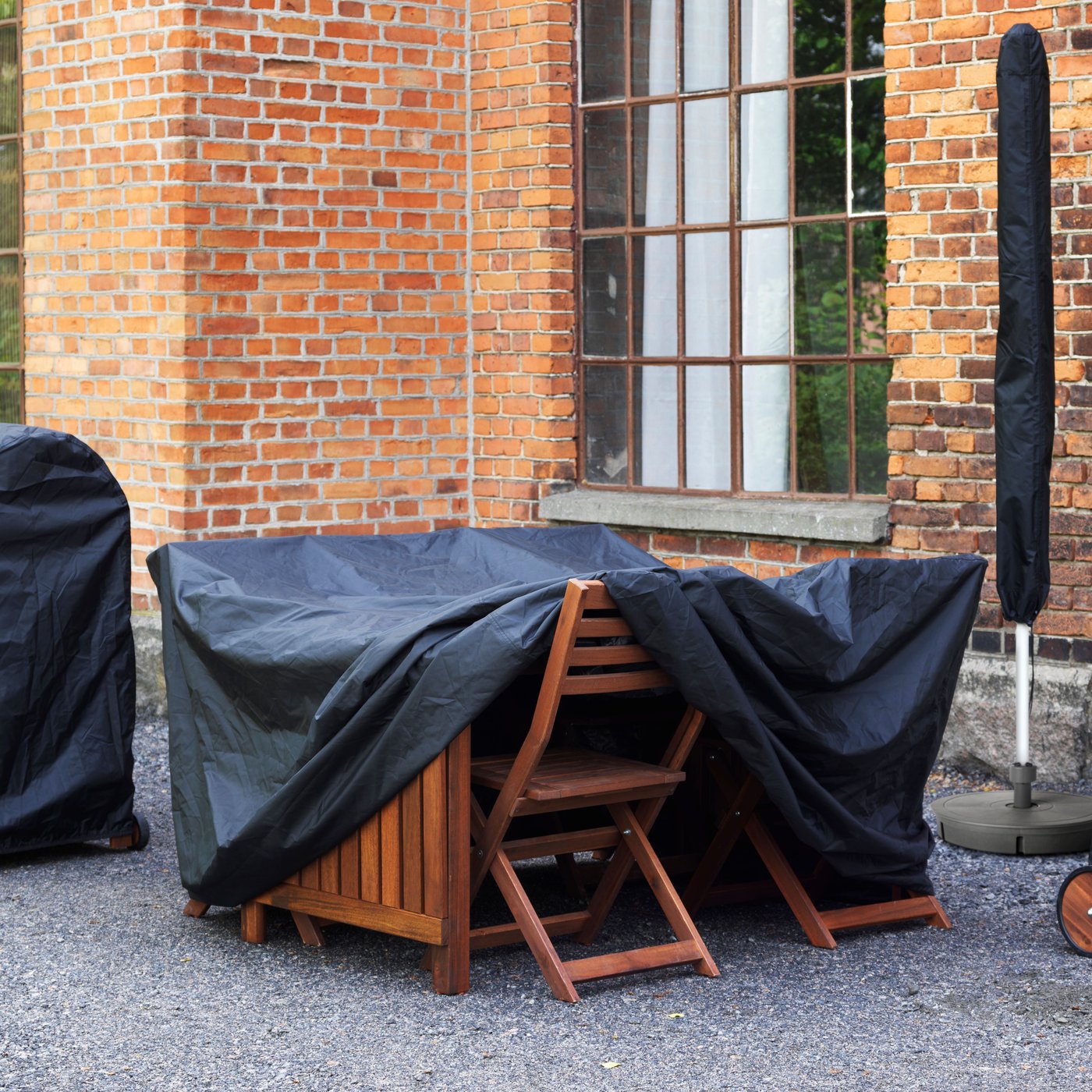 A black TOSTERÖ parasol cover outside