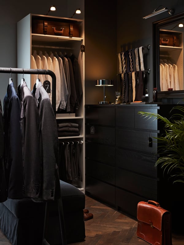 A man’s walk-in closet with jackets hanging on a TURBO clothes rack and ties hanging on BALUNGEN towel rails.