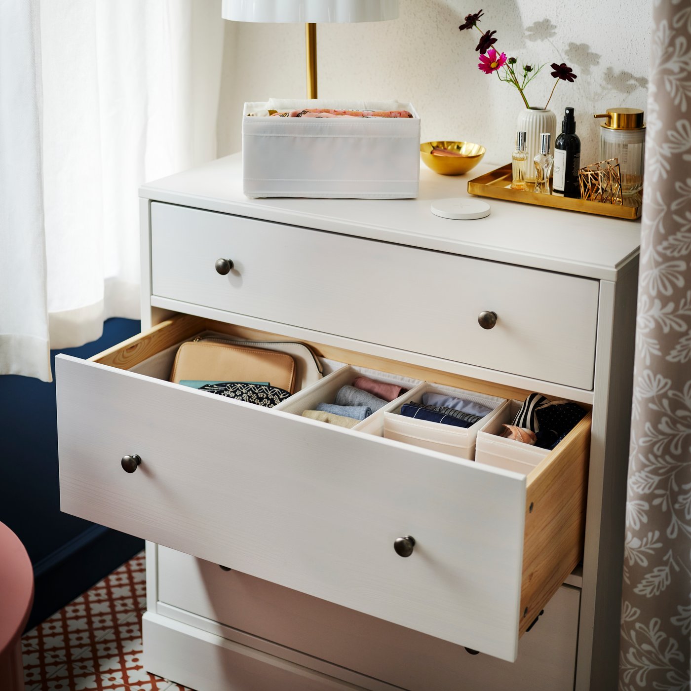 A HAVSTA chest of drawers with the middle drawer open showing folded clothes in SKUBB boxes. A white SKUBB box is on top.