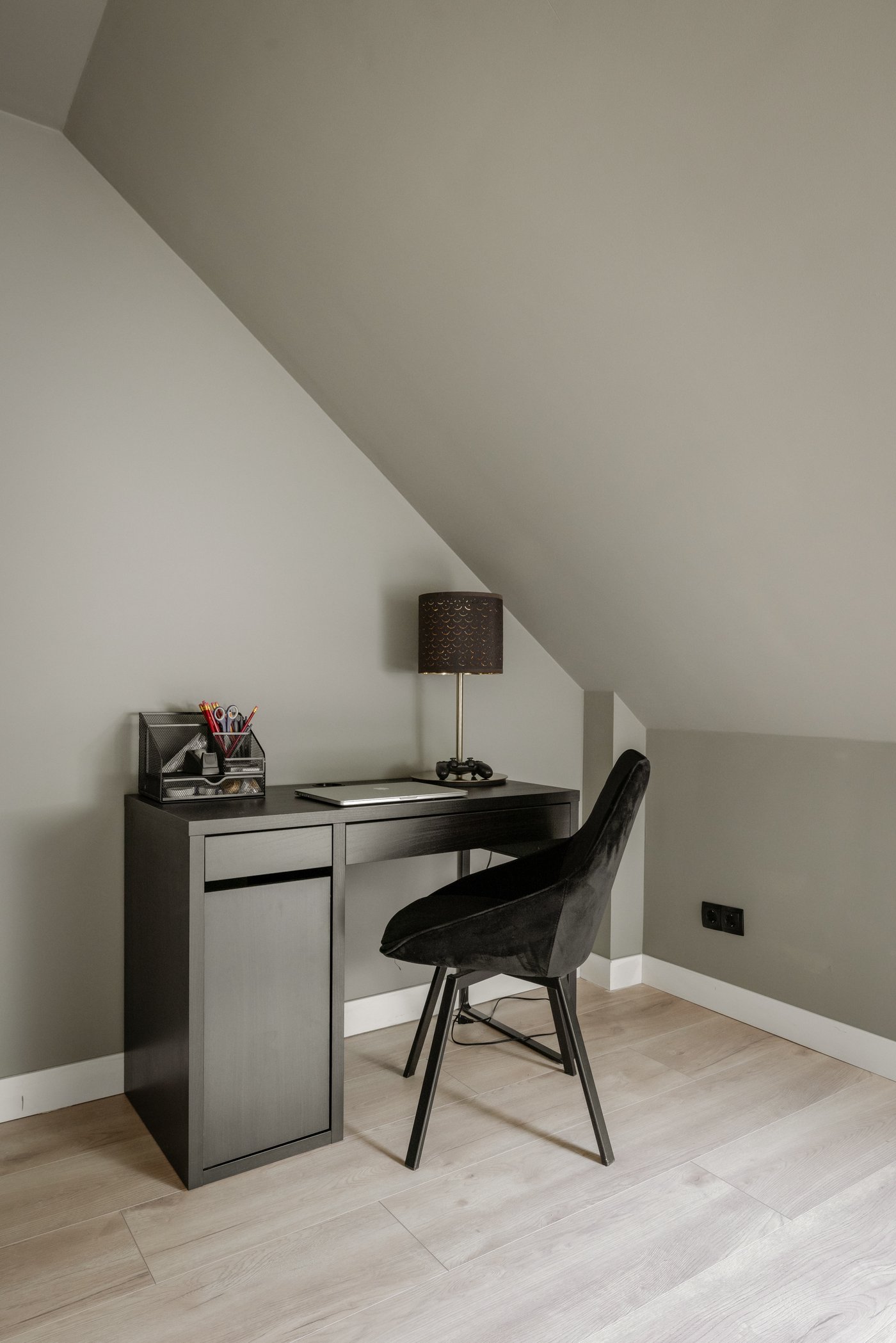 Zwart MICKE bureau met zwarte stoel. Op het bureau staat een NYMÖ / SKAFTET lamp.