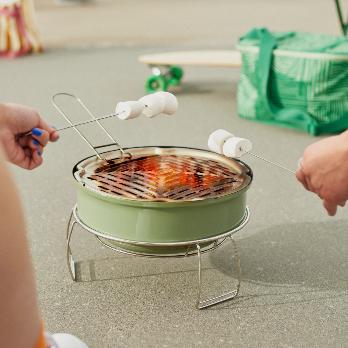 A patterned/green NÄBBFISK cooling bag