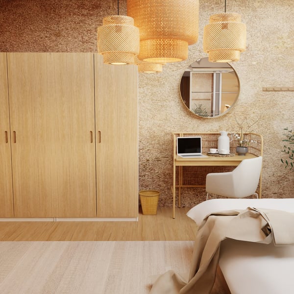 Teil eines Hotelzimmers. Blick auf den Kleiderschrank. Rechts neben dem Kleiderschrank ein Schminktisch mit Dekorationsgegenständen und davor ein gepolsterter Stuhl.