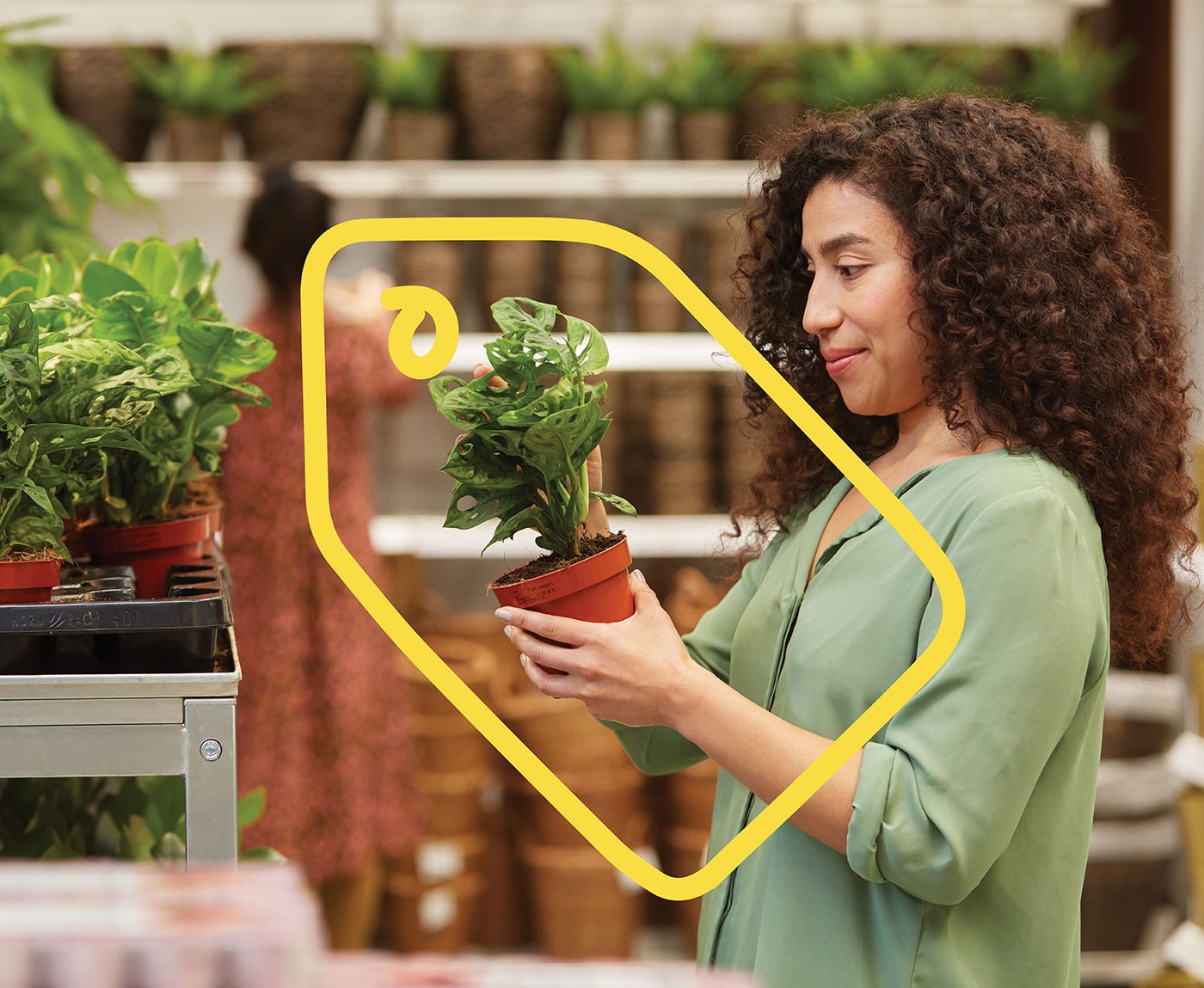 A person with a green shirt has a plant in their hand