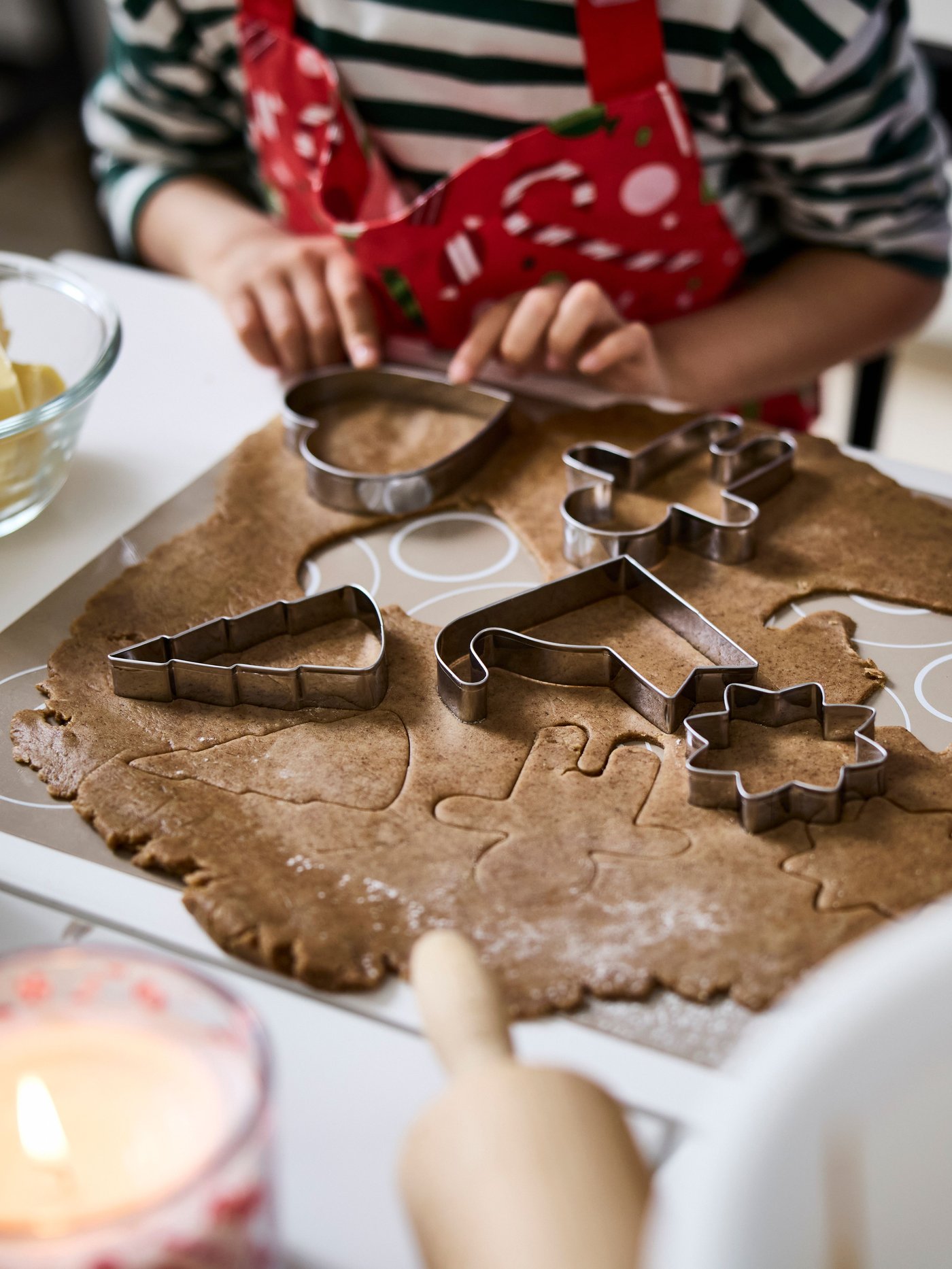 Otrok v kuhinji peče božične piškote z modelčki VINTERFINT.