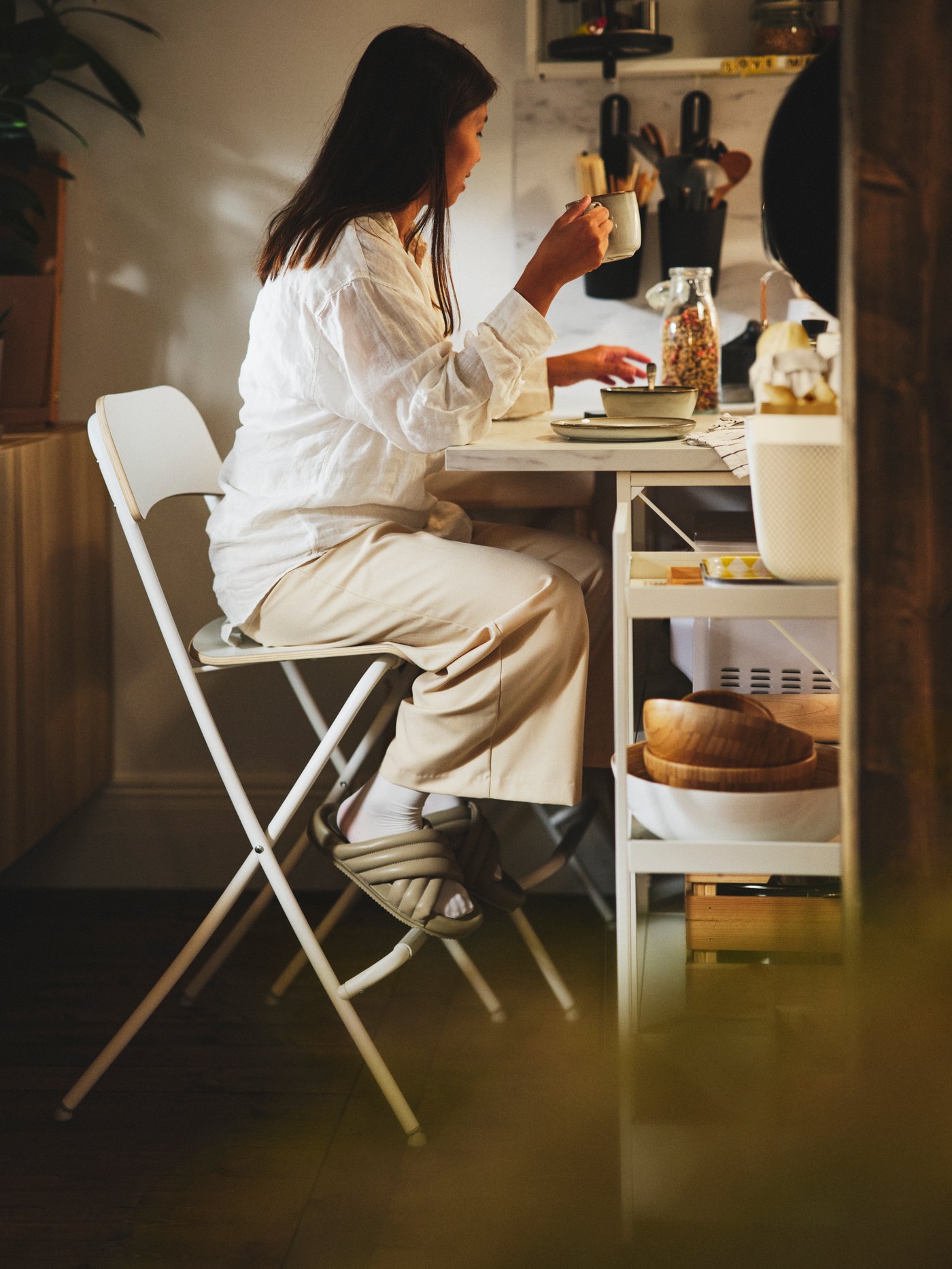 A women eating in her small dining on a chair