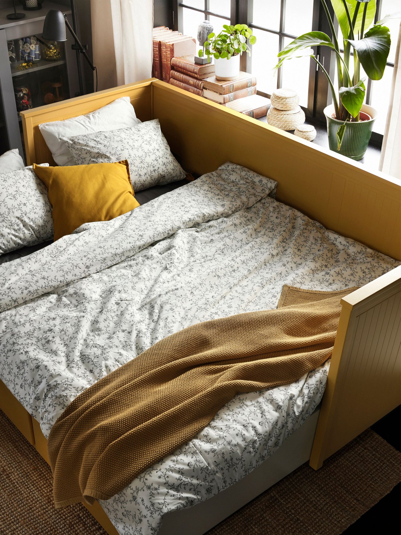 An yellow HEMNES day-bed frame with 3 drawers
