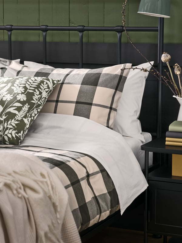 Black STJARNO bedframe with a GRAFJALLET bedside table next to it.  