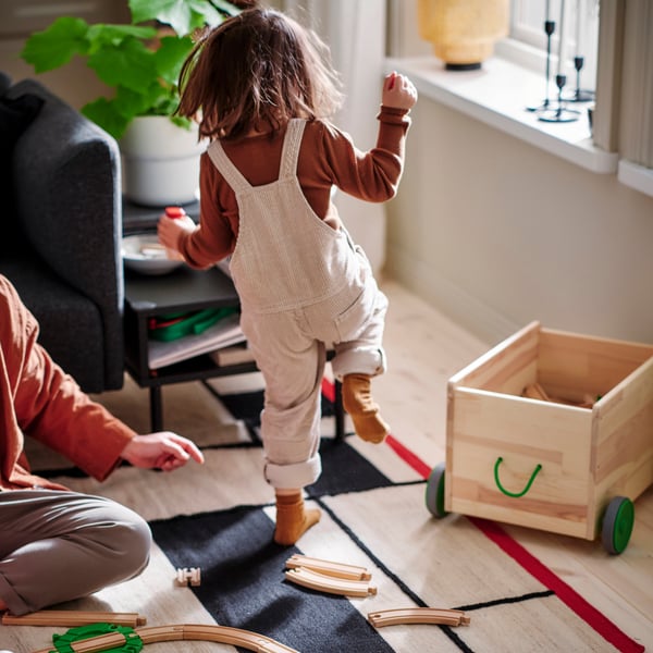 En jente leker i stua.