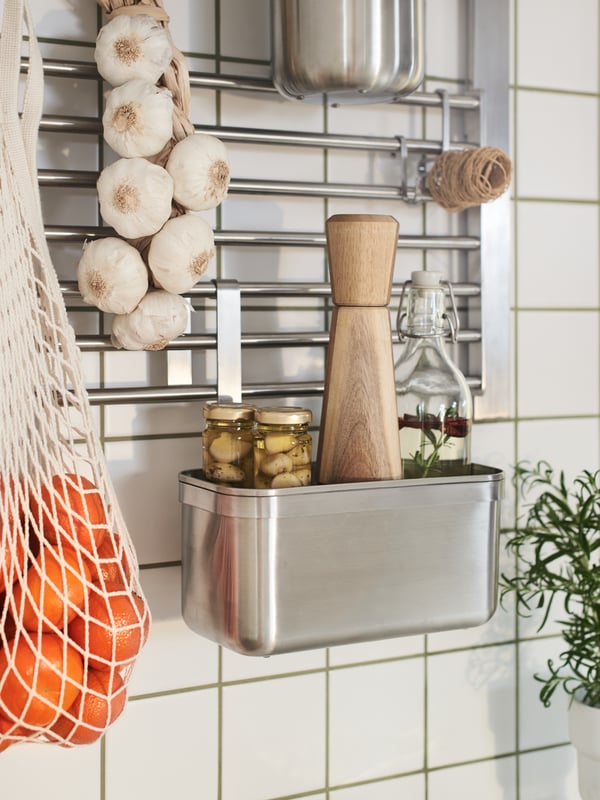 Stainless steel KUNGSFORS suspension rail with a shelf and wall grid holding glass jars with lids and white VARIERA boxes.