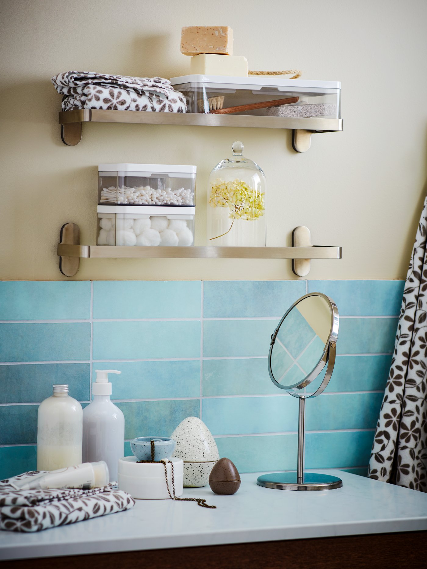 Twee metalen rekken gemonteerd op een badkamerwand met blauwe wandtegels.